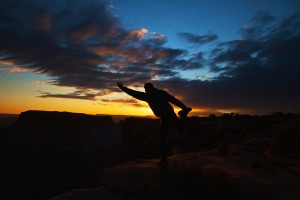 Image of man doing yoga on a cliff